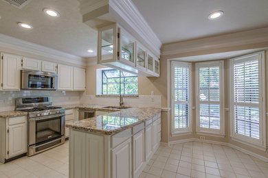 Eat-in kitchen - small traditional u-shaped ceramic tile and beige floor eat-in kitchen idea in Houston with an undermount sink, raised-panel cabinets, white cabinets, granite countertops, white backsplash, subway tile backsplash, stainless steel appliances and a peninsula