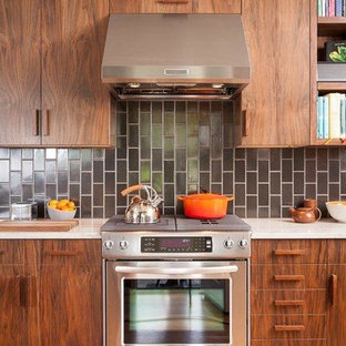 Midcentury separate kitchen in Portland with a farmhouse sink, flat-panel cabinets, dark wood cabinets, quartzite benchtops, black splashback, ceramic splashback, stainless steel appliances and light hardwood floors.