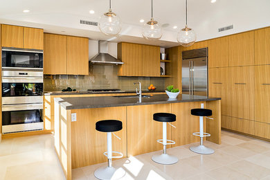 Example of a mid-sized minimalist u-shaped open concept kitchen design in Orange County with an undermount sink, medium tone wood cabinets, stainless steel appliances and an island