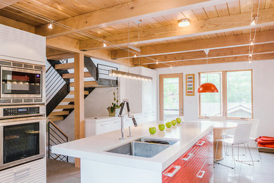 This is an example of a medium sized modern kitchen in Salt Lake City with a double-bowl sink, white cabinets, stainless steel appliances, an island and white floors.