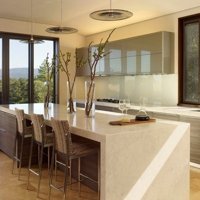 Inspiration for a contemporary galley kitchen remodel in San Francisco with a single-bowl sink, flat-panel cabinets, gray cabinets, white backsplash and glass sheet backsplash