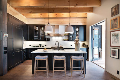 Kitchen - transitional l-shaped medium tone wood floor and brown floor kitchen idea in New York with shaker cabinets, black cabinets, white backsplash, stainless steel appliances, an island and white countertops