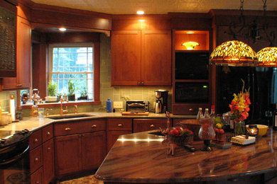 Kitchen - small traditional l-shaped light wood floor kitchen idea in Other with an undermount sink, shaker cabinets, medium tone wood cabinets, granite countertops, green backsplash, mosaic tile backsplash, black appliances and an island