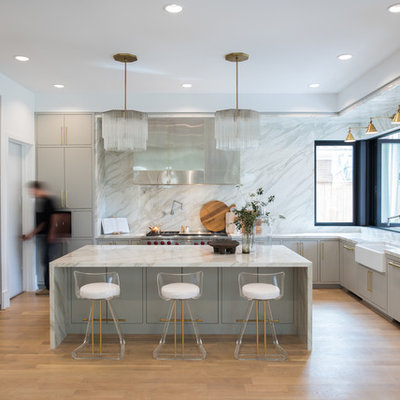 Inspiration for a large contemporary u-shaped light wood floor and beige floor kitchen remodel in Houston with a farmhouse sink, flat-panel cabinets, gray cabinets, marble countertops, white backsplash, marble backsplash, stainless steel appliances, an island and white countertops