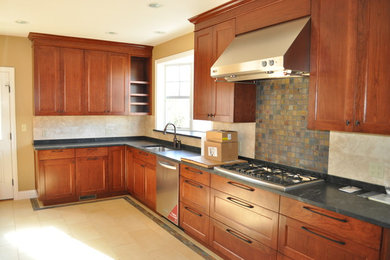 Example of a mid-sized transitional galley ceramic tile eat-in kitchen design in New York with a single-bowl sink, raised-panel cabinets, dark wood cabinets, marble countertops, beige backsplash, ceramic backsplash, stainless steel appliances and no island