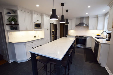 Mid-sized transitional l-shaped ceramic tile enclosed kitchen photo in Ottawa with an undermount sink, shaker cabinets, white cabinets, quartz countertops, white backsplash, subway tile backsplash, stainless steel appliances and an island
