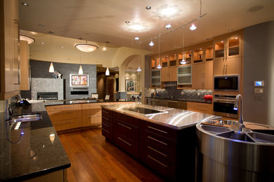 Example of a large trendy u-shaped light wood floor kitchen design in Denver with a double-bowl sink, flat-panel cabinets, light wood cabinets, quartz countertops, black backsplash, ceramic backsplash, stainless steel appliances and an island