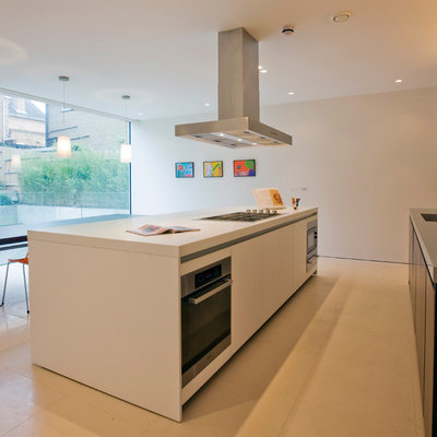Mid-sized minimalist single-wall eat-in kitchen photo in London with flat-panel cabinets, black cabinets, stainless steel appliances and an island