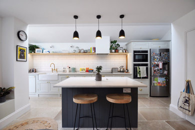 Example of a mid-sized trendy multicolored floor kitchen design in Other with shaker cabinets, marble countertops, subway tile backsplash and an island