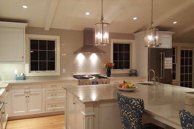 Photo of a medium sized traditional l-shaped open plan kitchen in Philadelphia with a belfast sink, beaded cabinets, white cabinets, quartz worktops, grey splashback, porcelain splashback, stainless steel appliances, light hardwood flooring and an island.