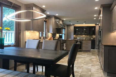 Example of a transitional porcelain tile and gray floor kitchen design in Philadelphia with an undermount sink, recessed-panel cabinets, gray cabinets, marble countertops, beige backsplash, stone tile backsplash and stainless steel appliances