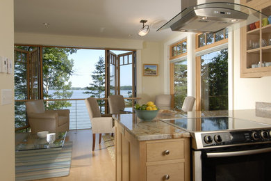 Example of a classic u-shaped eat-in kitchen design in Portland Maine with recessed-panel cabinets, light wood cabinets and stainless steel appliances