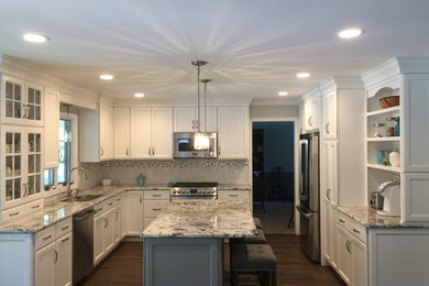 Mid-sized elegant u-shaped dark wood floor and brown floor eat-in kitchen photo in Philadelphia with a double-bowl sink, recessed-panel cabinets, white cabinets, granite countertops, beige backsplash, stainless steel appliances and an island