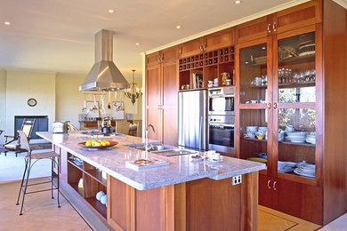 Bild på ett mellanstort vintage linjärt kök med öppen planlösning, med en dubbel diskho, skåp i shakerstil, skåp i mellenmörkt trä, bänkskiva i kvarts, rostfria vitvaror, mellanmörkt trägolv och en köksö