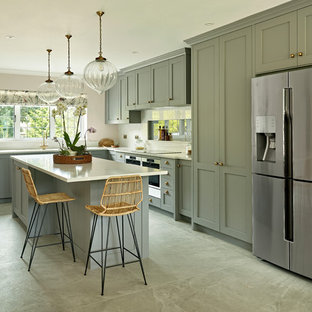 Inspiration for a traditional l-shaped kitchen in Surrey with shaker cabinets, grey cabinets, white splashback, stainless steel appliances, an island, grey floors and white worktops.