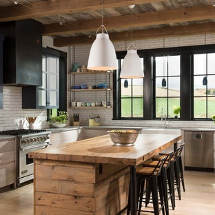 This is an example of a country l-shaped kitchen in Other with a farmhouse sink, open cabinets, light wood cabinets, wood benchtops, white splashback, subway tile splashback, coloured appliances, light hardwood floors, with island and beige floor.