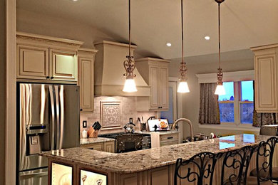 Inspiration for a large timeless single-wall ceramic tile open concept kitchen remodel in New York with raised-panel cabinets, white cabinets, granite countertops, beige backsplash, stone tile backsplash, stainless steel appliances, an island and an undermount sink