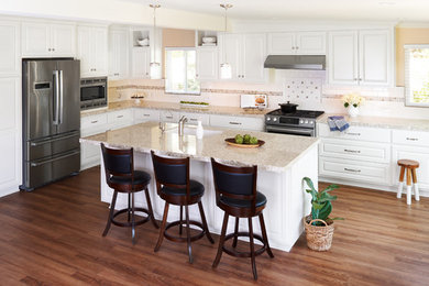 Example of a mid-sized transitional l-shaped brown floor open concept kitchen design in Orange County with an undermount sink, raised-panel cabinets, white cabinets, quartz countertops, white backsplash, stainless steel appliances, an island and ceramic backsplash