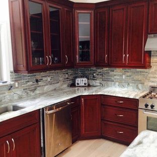 Photo of a large traditional l-shaped eat-in kitchen in New York with an undermount sink, recessed-panel cabinets, dark wood cabinets, quartzite benchtops, multi-coloured splashback, slate splashback, stainless steel appliances, light hardwood floors, with island, beige floor and multi-coloured benchtop.