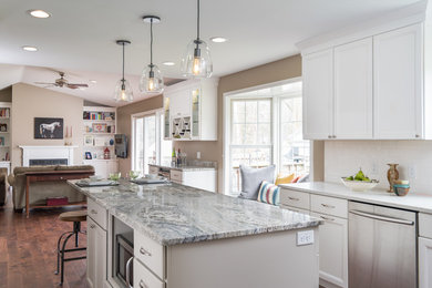 Example of a transitional l-shaped dark wood floor and brown floor kitchen design in Grand Rapids with an undermount sink, shaker cabinets, white cabinets, white backsplash, subway tile backsplash, stainless steel appliances and an island