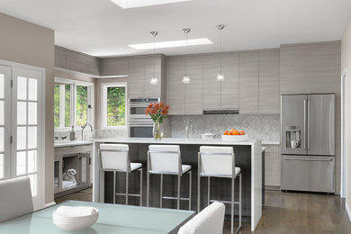 Example of a mid-sized trendy l-shaped medium tone wood floor and brown floor eat-in kitchen design in St Louis with flat-panel cabinets, gray cabinets, gray backsplash, stainless steel appliances, an island, white countertops, quartz countertops and porcelain backsplash