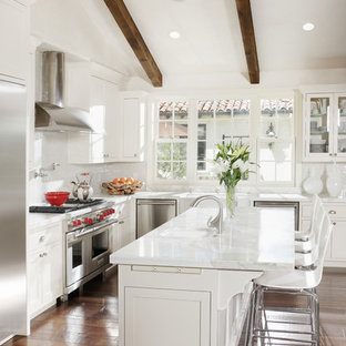 Example of a tuscan l-shaped kitchen design in San Francisco with shaker cabinets, white cabinets, white backsplash and stainless steel appliances