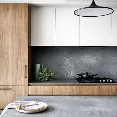 Example of a mid-sized trendy galley eat-in kitchen design in Sydney with an undermount sink, flat-panel cabinets, medium tone wood cabinets, glass countertops, gray backsplash, stone slab backsplash, black appliances, a peninsula and gray countertops