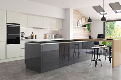 Design ideas for a medium sized modern galley open plan kitchen in Oxfordshire with flat-panel cabinets, grey cabinets, quartz worktops, an island and black worktops.