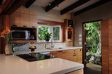 Example of a mid-sized island style u-shaped eat-in kitchen design in Hawaii with an undermount sink, flat-panel cabinets, medium tone wood cabinets, quartzite countertops, green backsplash, mosaic tile backsplash and stainless steel appliances