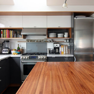 Modern kitchen in Seattle with open cabinets, black cabinets, quartz benchtops, grey splashback, glass sheet splashback and stainless steel appliances.