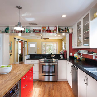 Large transitional l-shaped eat-in kitchen in Austin with a double-bowl sink, glass-front cabinets, white cabinets, stainless steel appliances, quartz benchtops, red splashback, light hardwood floors and multiple islands.