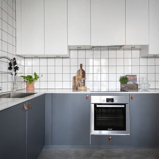 Idéer för minimalistiska vitt u-kök, med en enkel diskho, släta luckor, grå skåp, vitt stänkskydd, rostfria vitvaror, betonggolv och grått golv