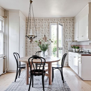 Idéer för att renovera ett skandinaviskt brun brunt parallellkök, med släta luckor, vita skåp, vitt stänkskydd, vita vitvaror, ljust trägolv och beiget golv