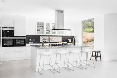 Inspiration för moderna kök, med vita skåp, svarta vitvaror och en köksö