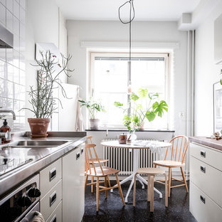 Idéer för ett litet minimalistiskt kök, med släta luckor, grå skåp, bänkskiva i rostfritt stål, vitt stänkskydd, linoleumgolv och svart golv