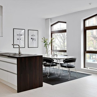 Inspiration för ett stort minimalistiskt kök, med släta luckor, vita skåp, träbänkskiva, vinylgolv, en halv köksö, en undermonterad diskho, rostfria vitvaror och beiget golv