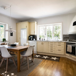 Bild på ett mellanstort skandinaviskt grå grått kök, med luckor med upphöjd panel, beige skåp, grått stänkskydd, mellanmörkt trägolv och brunt golv