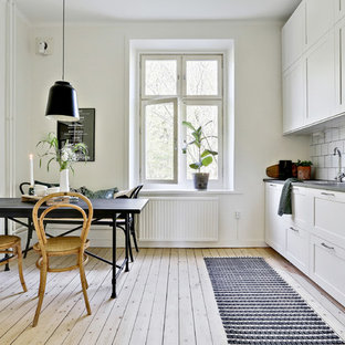 Idéer för att renovera ett skandinaviskt grå linjärt grått kök och matrum, med skåp i shakerstil, vita skåp, vitt stänkskydd, ljust trägolv och beiget golv