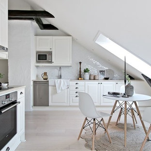 Inspiration för ett mellanstort, avskilt nordiskt grå grått l-kök, med vita skåp, vitt stänkskydd, stänkskydd i mosaik, rostfria vitvaror, beiget golv, en rustik diskho, luckor med upphöjd panel och ljust trägolv
