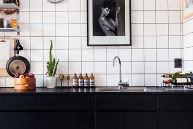 Foto de cocina lineal urbana con armarios con paneles lisos y puertas de armario negras