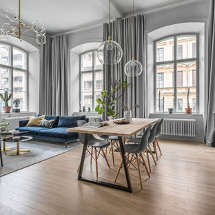 Modern inredning av ett mellanstort linjärt kök med öppen planlösning, med en rustik diskho, släta luckor, gröna skåp, grått stänkskydd, mellanmörkt trägolv och brunt golv