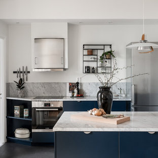 Idéer för att renovera ett minimalistiskt grå grått parallellkök, med en undermonterad diskho, släta luckor, blå skåp, marmorbänkskiva, grått stänkskydd, stänkskydd i marmor, rostfria vitvaror, en halv köksö och svart golv