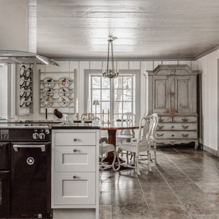 Exempel på ett shabby chic-inspirerat svart svart kök och matrum, med skåp i shakerstil, vita skåp, svarta vitvaror, en halv köksö och grått golv