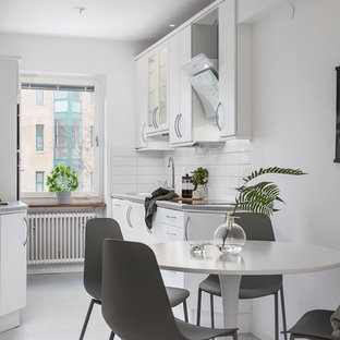 Idéer för att renovera ett minimalistiskt grå grått kök, med en undermonterad diskho, släta luckor, vita skåp, vitt stänkskydd, vita vitvaror, bambugolv och vitt golv