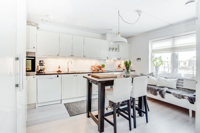 Einzeilige Nordische Wohnküche mit Doppelwaschbecken, beigen Schränken, Küchenrückwand in Weiß, Rückwand aus Metrofliesen, weißen Elektrogeräten, hellem Holzboden, Kücheninsel und weißem Boden in Stockholm