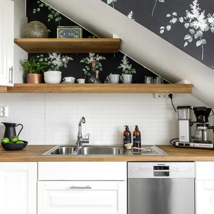 Esempio di una cucina a L nordica con lavello a doppia vasca, ante con bugna sagomata, ante bianche, top in legno, paraspruzzi bianco, paraspruzzi con piastrelle diamantate e elettrodomestici in acciaio inossidabile