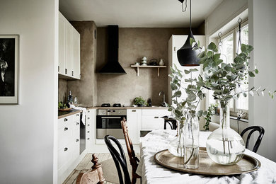 Bild på ett mellanstort skandinaviskt kök, med luckor med infälld panel och vita skåp