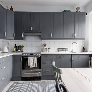 Exempel på ett mellanstort nordiskt kök, med en nedsänkt diskho, luckor med profilerade fronter, grå skåp, laminatbänkskiva, vitt stänkskydd, stänkskydd i keramik, svarta vitvaror, ljust trägolv och vitt golv