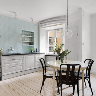 Inspiration för ett stort skandinaviskt svart svart kök och matrum, med vita skåp, blått stänkskydd, stänkskydd i glaskakel, ljust trägolv, beiget golv, en undermonterad diskho, luckor med upphöjd panel och rostfria vitvaror