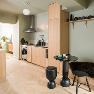 Inredning av ett nordiskt litet beige beige kök, med skåp i ljust trä, granitbänkskiva, ljust trägolv, beiget golv, en undermonterad diskho, släta luckor, beige stänkskydd, stänkskydd i sten och rostfria vitvaror